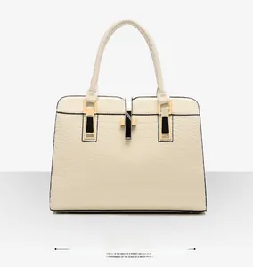 Détail de face du sac à main blanc cassé avec motif crocodile et fermoir en métal doré