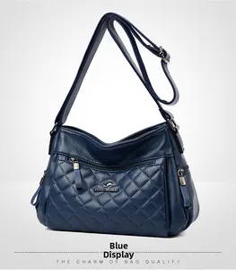 Macro shot of blue quilted crossbody bag with soft lychee texture and metallic kangaroo logo