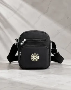 Detail of waterproof black oxford crossbody bag with adjustable strap and multiple zippers