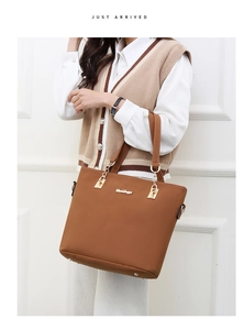 Close-up of brown leather tote bag with gold chain and metal logo on model
