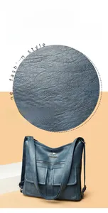 Detalle del bolso de cuero azul con textura fina y dos bolsillos delanteros con solapa