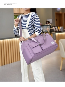 Detail of a purple high-capacity waterproof travel bag with adjustable strap and pockets