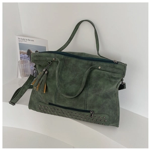 Detail view of retro green tote bag with metal rivets and leather tassel charm