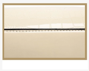 Détail du cuir crème à motif crocodile avec coutures précises et finition des bords noirs