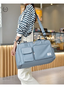 Detail of waterproof nylon travel bag showing functional pockets and navy blue texture