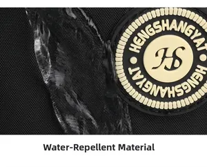 Close-up of waterproof black oxford fabric with water droplets and rubber logo