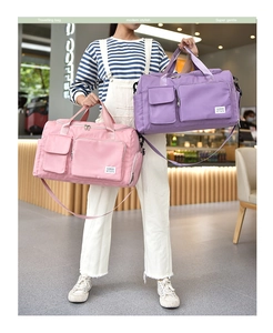 Detail view of pink and purple waterproof travel bags with multiple pockets and shoe compartment