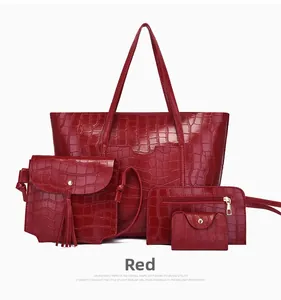 Detail of red crocodile pattern handbag set including large tote and fringed shoulder bag