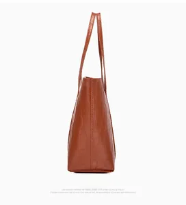 Vista laterale della borsa tote marrone in ecopelle con motivo a pelle di coccodrillo