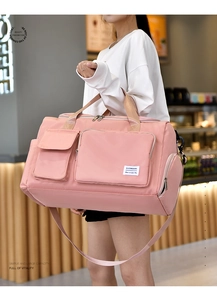 Detail of pink waterproof nylon travel bag with multiple pockets and adjustable shoulder strap