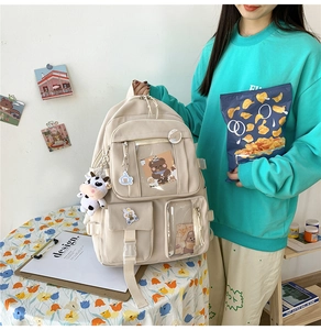 Détail du sac à dos en toile crème avec poches transparentes et accessoires de dessin animé