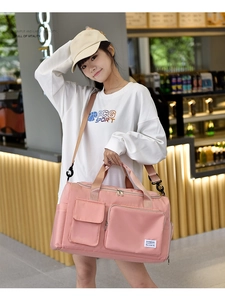 Detail of pink waterproof travel bag with adjustable strap and multi-pocket design