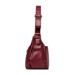 Deep red pebbled leather crossbody bag with quilted stitching and adjustable strap
