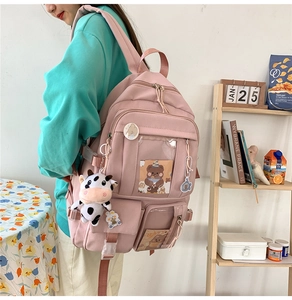 Détail d'un sac à dos rose pour étudiante avec peluche vache et poche transparente