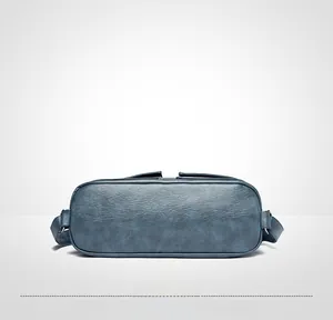 Vista de la base ovalada ancha y textura retro de este bolso de hombro azul marino