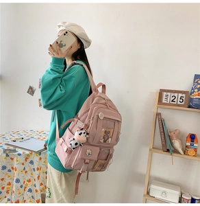 Vue détaillée du sac à dos rose multi-poches avec son pendentif vache décoratif