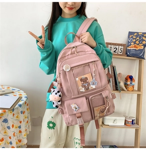Sac à dos scolaire rose avec fenêtre transparente et badges de dessin animé sur le modèle