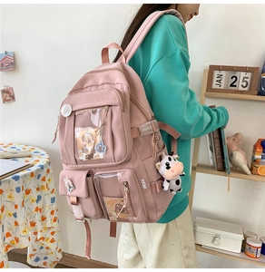 Sac à dos d'école rose avec pendentif vache en peluche et écussons décoratifs de profil