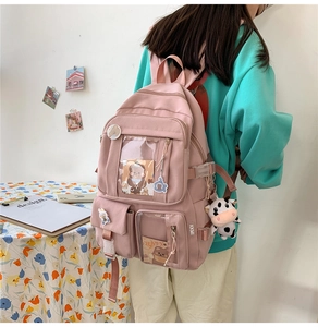 Vue détaillée d'un sac à dos rose avec des breloques en peluche et des fenêtres en PVC