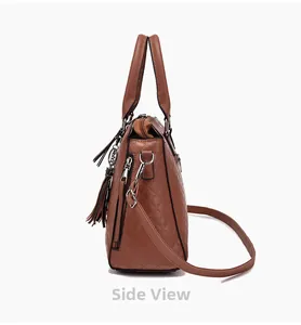 Vue latérale du sac à main matelassé marron avec pompons en cuir et détails zippés