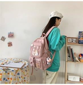 Vue détaillée latérale d'un sac à dos rose multi-poches avec pendentif vache et breloques