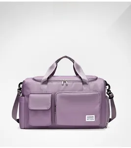 Detailed view of purple waterproof travel bag featuring reinforced handles and logo