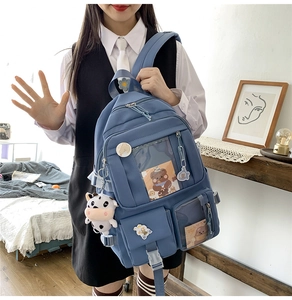 Détail de sac à dos bleu pour étudiante avec fenêtre transparente et porte-clés peluche