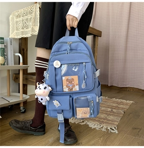 Détail d'un sac à dos scolaire bleu avec fenêtre transparente et accessoires de dessin animé