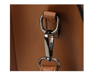 Detail van de metalen hardware en karabijnsluiting op een bruine lederen tas