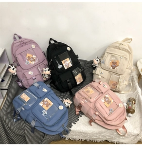 Détail de sacs à dos en nylon à poches multiples en cinq couleurs avec charmants badges