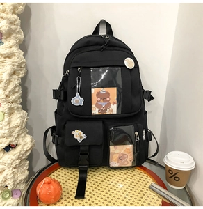 Détails du sac à dos noir multi-poches avec breloques d'ours et badges décoratifs