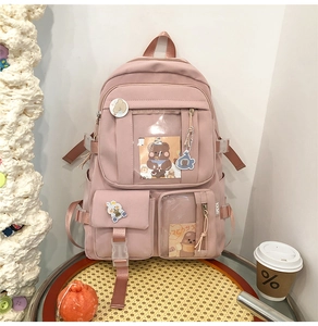Détails d'un sac à dos scolaire rose avec fenêtres transparentes et badges de dessins animés