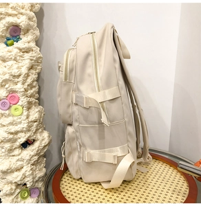Détails du sac à dos blanc cassé avec boucles latérales réglables et fermetures éclair