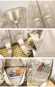 Détail d'un sac à dos de voyage beige montrant les poignées renforcées et compartiments