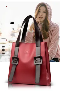 Detail of red litchi texture tote bag with brown handles and kangaroo embossed logo