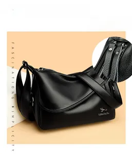 Detail of black pebbled leather crossbody bag showing dual zipper and fine stitching