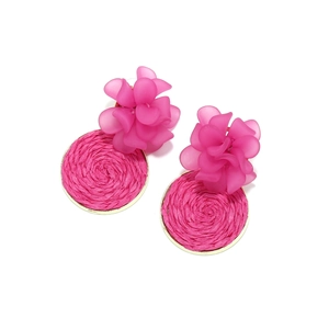 Detail of hot pink layered flower earrings with woven raffia disc and gold metal frame