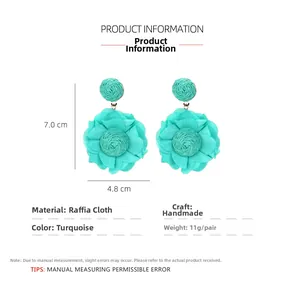 Detail of teal raffia and chiffon floral earrings with dimensions 7.0cm by 4.8cm
