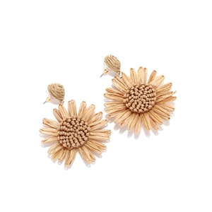 Vue macro de boucles d'oreilles tournesol en raphia fait main avec texture tissée et clous