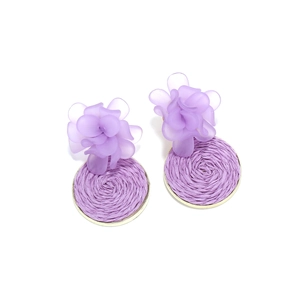 Detail of handmade woven raffia floral earrings with purple resin petals and gold trim