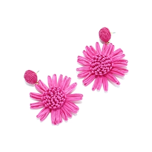 Détail des boucles d'oreilles fleurs en raphia tissé rose fuchsia fait main