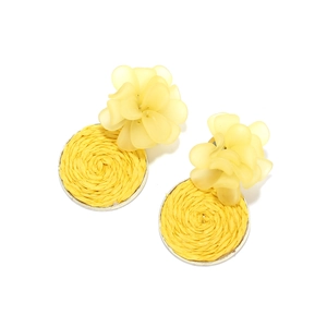 Detail of yellow handmade resin flower earrings with raffia woven disc and silver frame