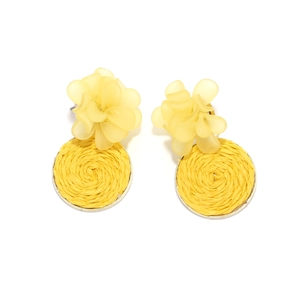 Macro shot of yellow resin flower earrings with raffia woven round charms and gold posts