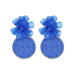 Close-up of blue resin flower petals and woven texture in a gold metal frame earring