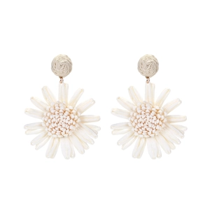 Gros plan détaillé de boucles d'oreilles tournesol en raphia blanc avec texture tissée