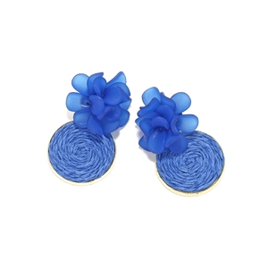 Close-up of handmade blue resin flower earrings with raffia woven textures and gold edges