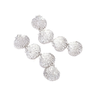 Macro shot of silver tiered seashell drop earrings with detailed ocean textures