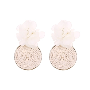 Detailed shot of handmade woven raffia floral earrings with elegant white resin petals