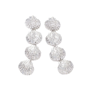 Close-up of silver layered shell drop earrings with detailed radial ribbed texture