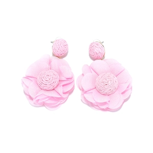 Detailed close-up of large pink chiffon fabric flower earrings with woven raffia centers